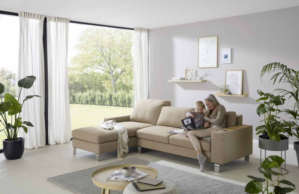 braunes Sofa mit Recamiere, auf dem eine Frau mit ihrem Enkel sitzt