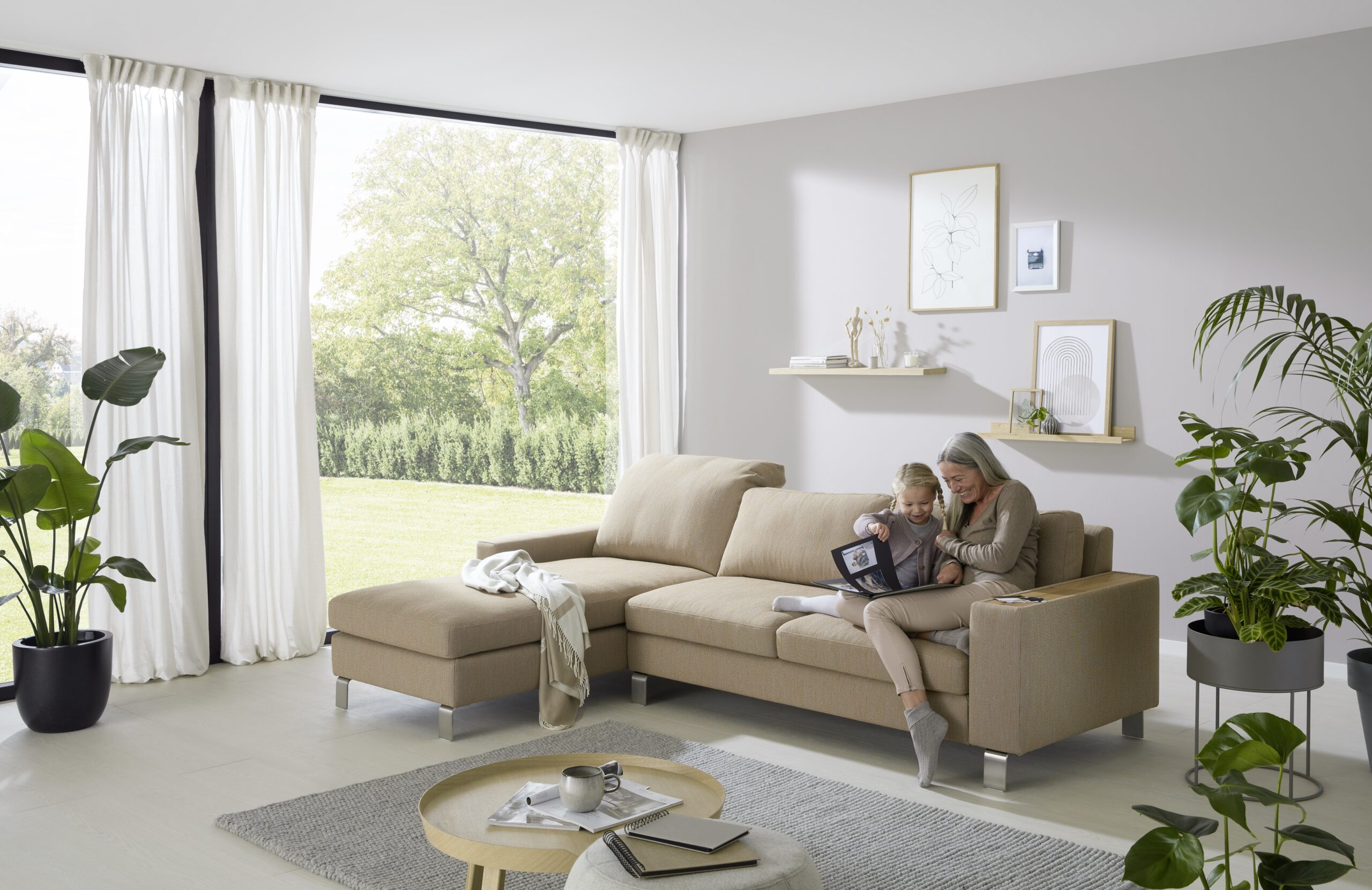 braunes Sofa mit Recamiere, auf dem eine Frau mit ihrem Enkel sitzt