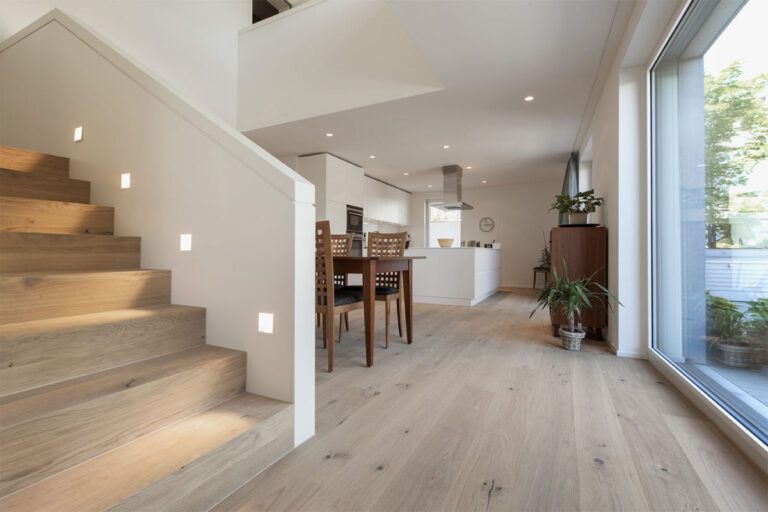 Erdgeschoss mit Treppe ins Obergeschoss, Boden und Treppe in Holz, Blick in offene Wohnküche