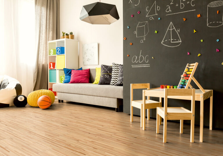 Kinderzimmer mit großer Tafel, Schlafsofa, Holzboden in Stäbchenoptik