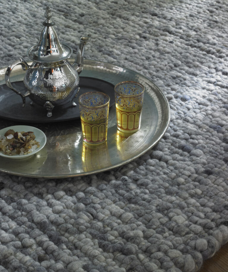 grauer Wollteppich mit orientalischem Teetablett
