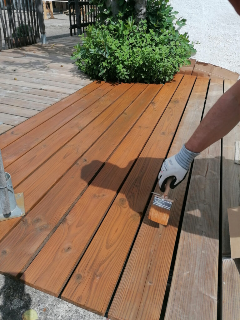 Eine Holzterrasse wird geölt