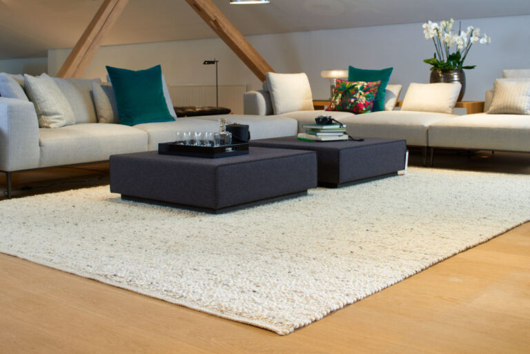Wohnzimmer unter dem Dach mit großer Sofa-Landschaft und Wollteppich