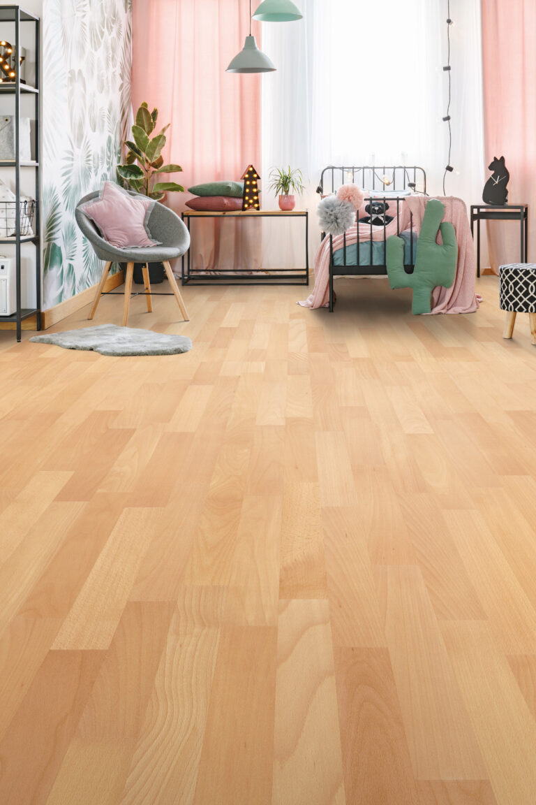 Jugendzimmer mit Buche-Fertigparkett, grauer Sessel, pinke Textilien