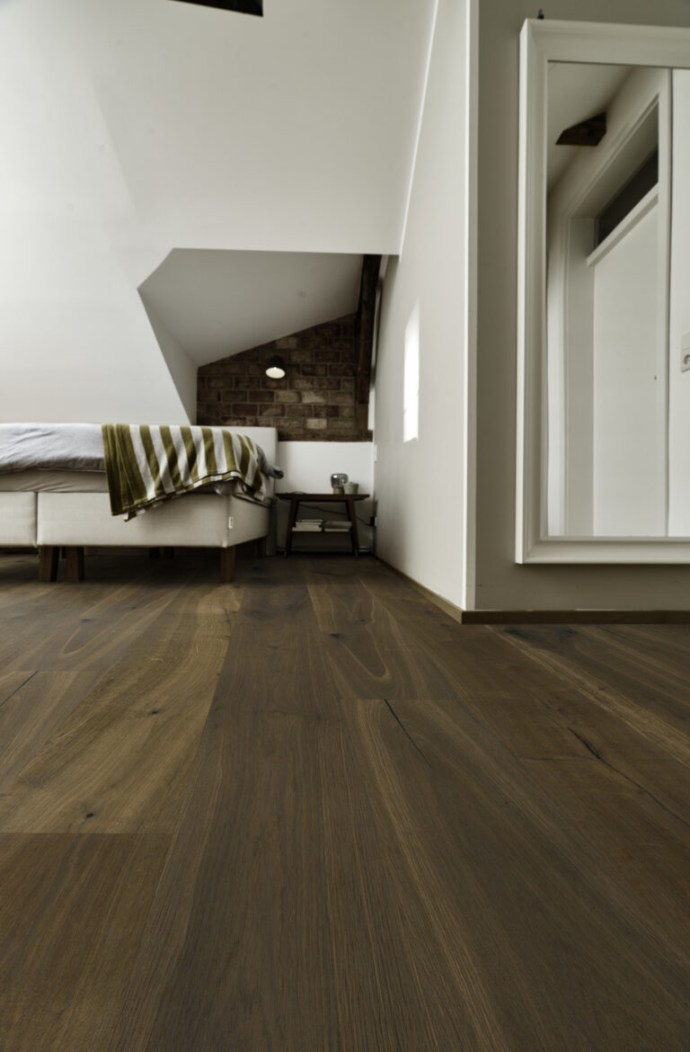 Nahaufnahme Schlafzimmer mit dunklem Eicheboden und weißen Möbeln