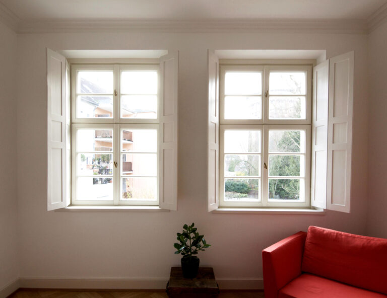 Zimmer mit rotem Sofa und Sprossenfenster mit Oberlichtern