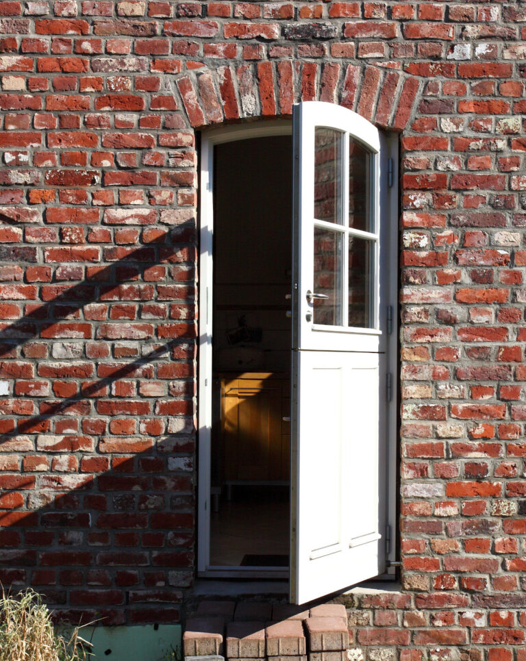 weiße Klöntür in Backstein-Fassade