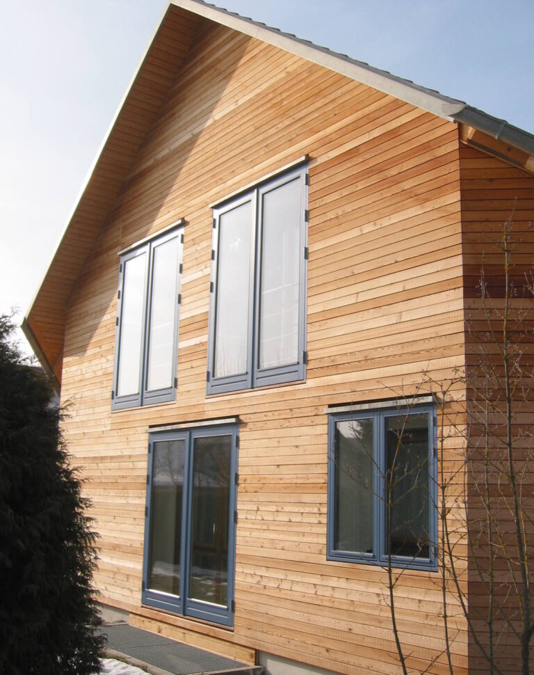 Holzfassade mit grauen Fenstern