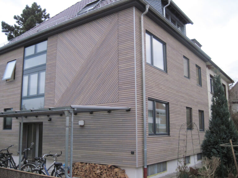 frisch renoviertes Haus mit Holzverkleidung und grauen Fenstern