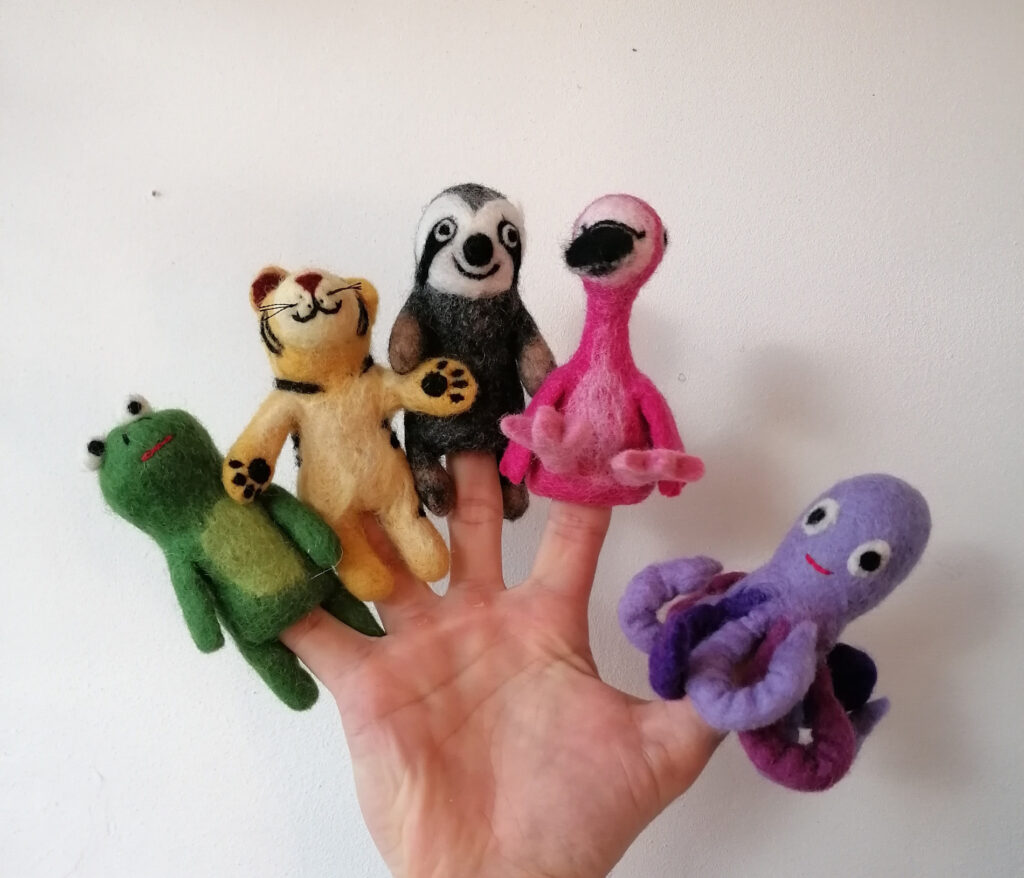 Fingerpuppen aus Wollfilz Hand, auf deren Finger jeweils eine Tier-Fingerpuppe steckt