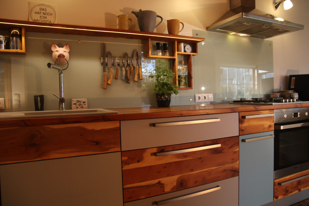 Küche mit wild gemasertem Holz und bunten Fronten