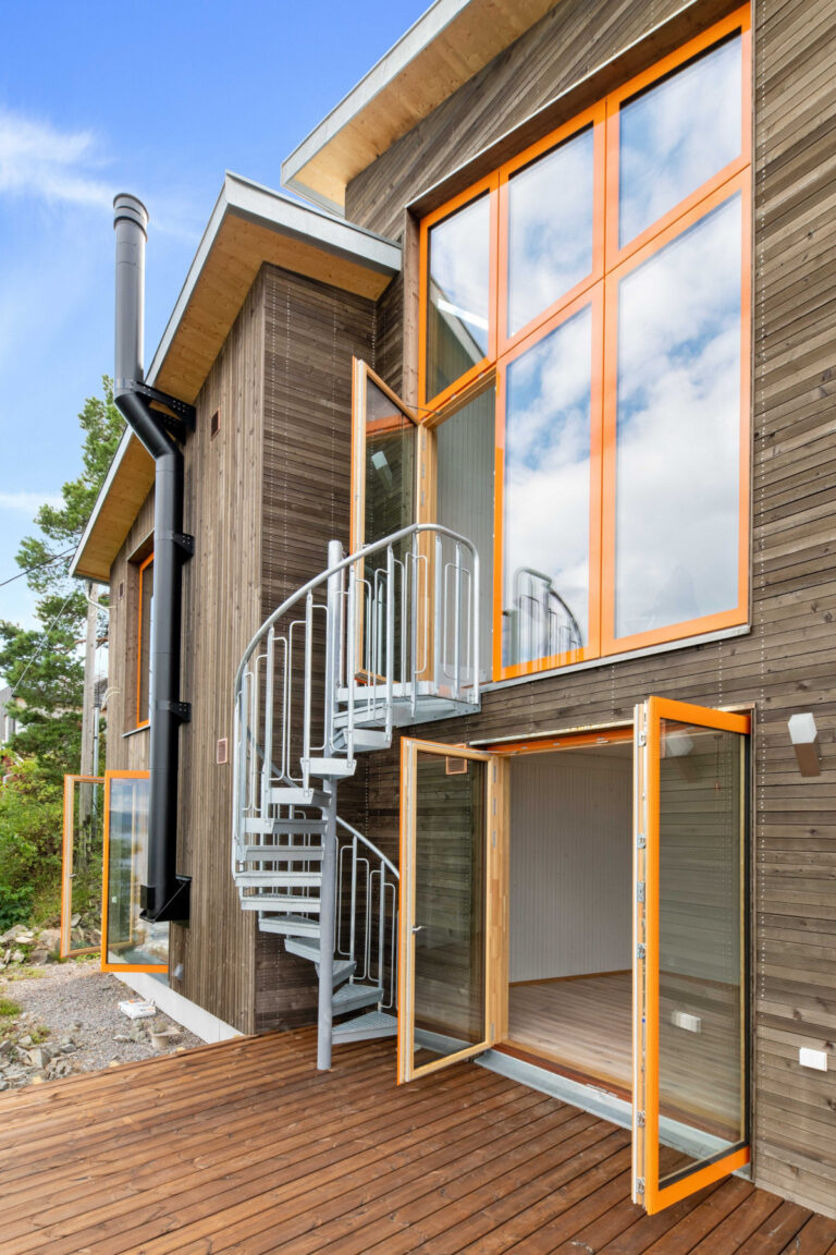 Haus mit Holzfassade und gelben Fenstern, Wendeltreppe in den ersten Stock