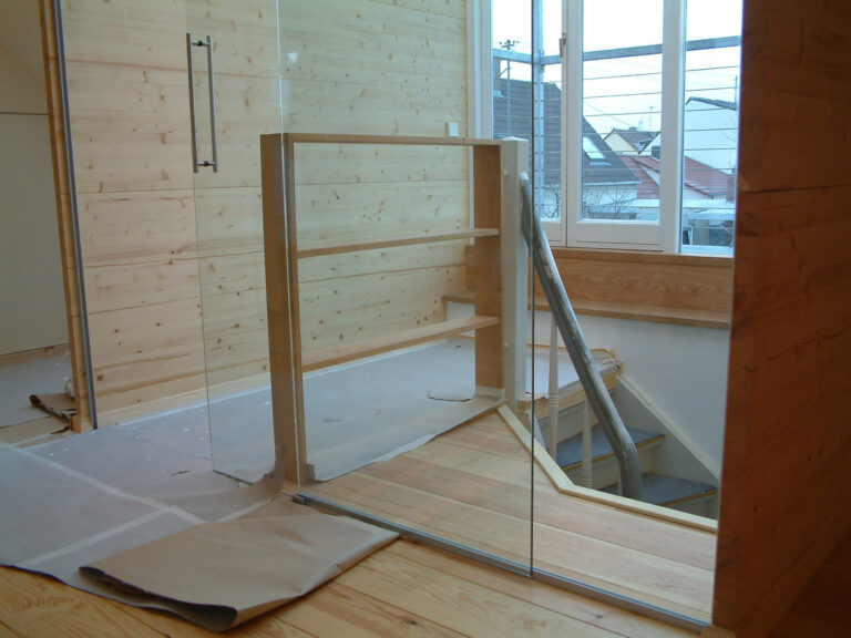 Ausbau Dachgeschoss mit Wänden aus Nadelholz und Glastrennwand zum Treppenhaus