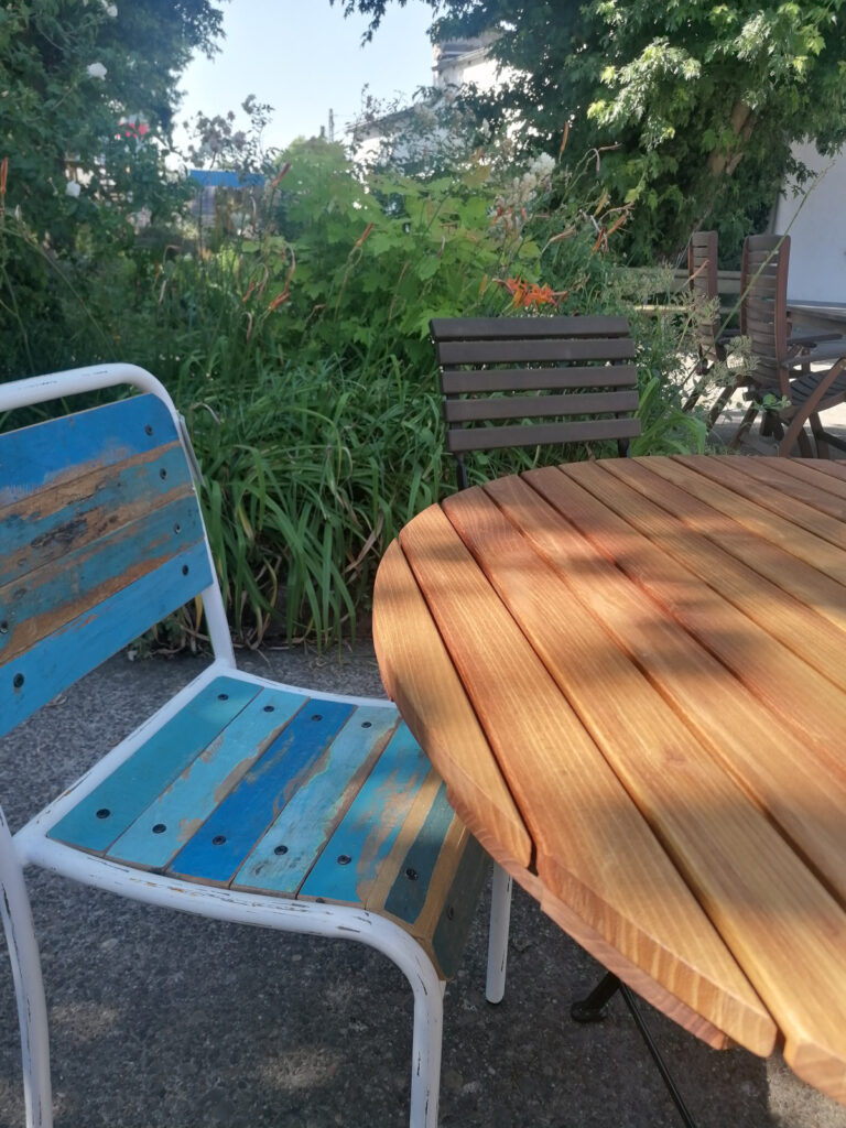 verschiedene Gartenmöbel in einem begrünten Innenhof