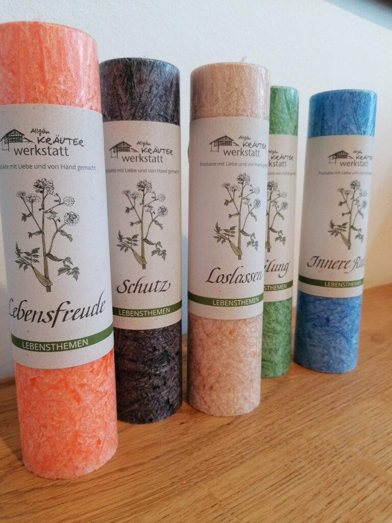 bunte Kerzen mit Banderole, auf der "Lebensthemen" wie Innere Ruhe stehen
