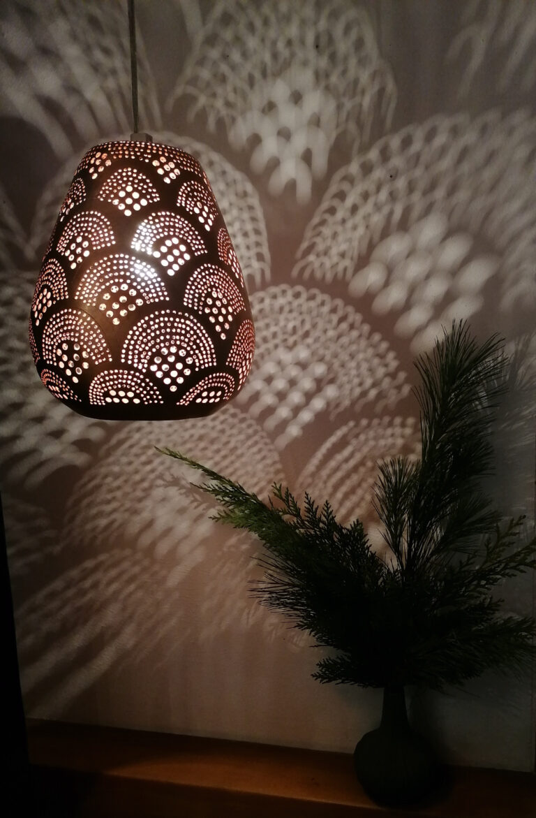 Hängelampe aus Kupfer mit gebohrtem Muster wirft Lichtspiel an die Wand