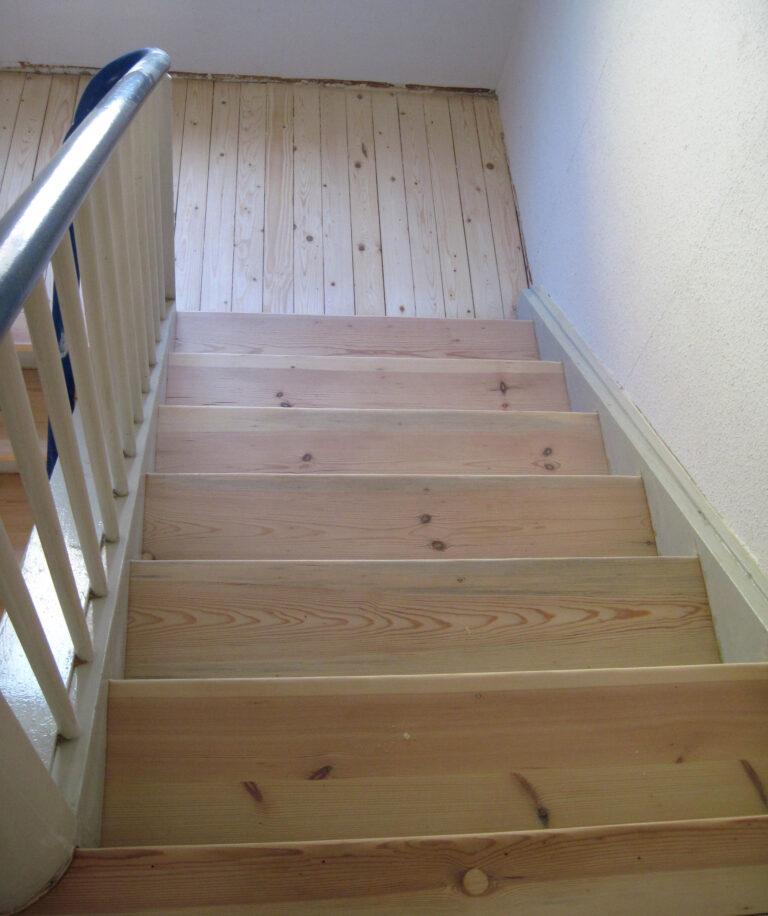 Treppenhaus mit frisch renovierter Holztreppe