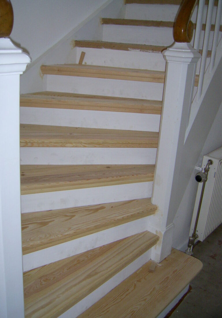 Treppenhaus mit frisch renovierter Holztreppe
