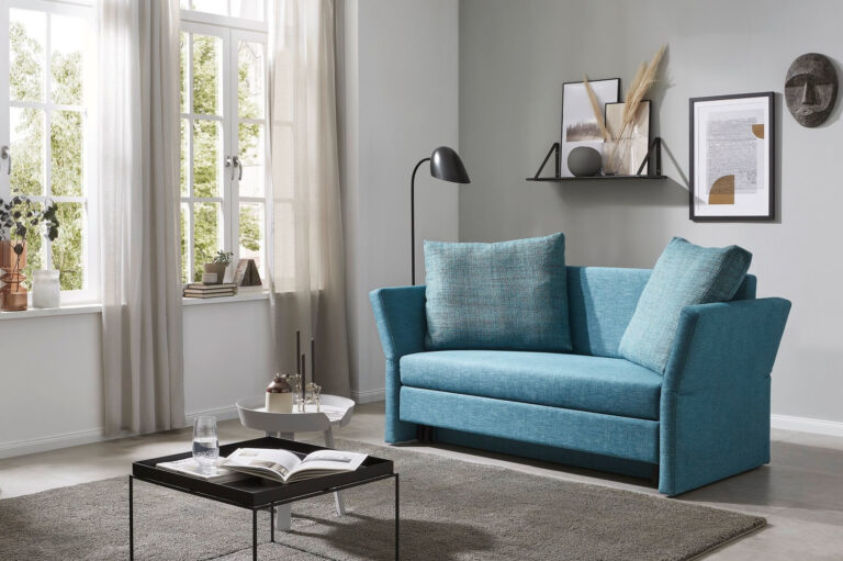 blaues Sofa mit hohen abklappbaren Armlehnen
