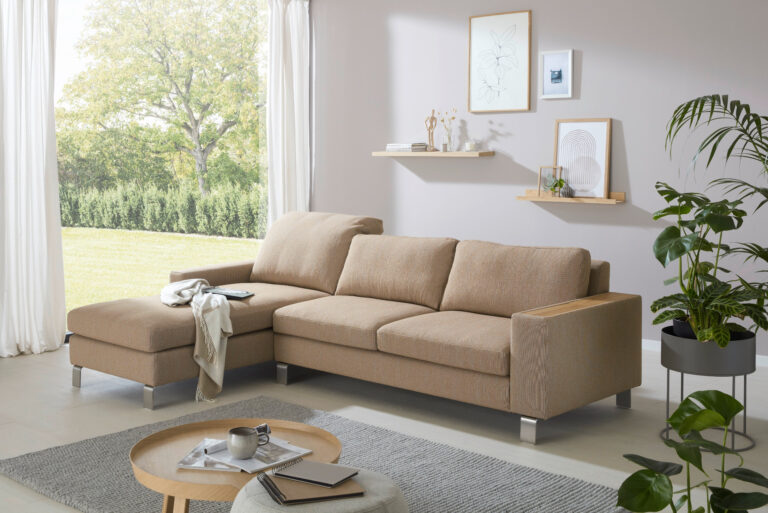 braunes Sofa mit Recamiere, das Kissen an der Recamiere ist runtergeklappt