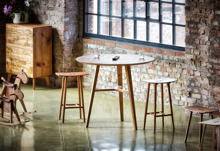 Stehtisch mit zwei eleganten Barhockern in einer Industriehalle