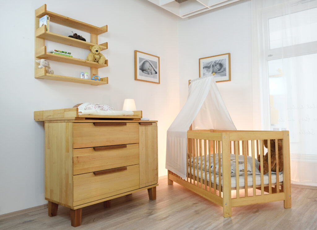 Benevita: Der Aufsatz der Wickelkommode kann zum Regal umgebaut werden. Kinderzimmer mit Babybett und Wickelkommode aus hellem Holz