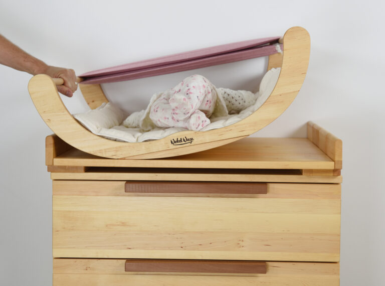 Wickelwiege auf einer Wickelkommode aus hellem Holz