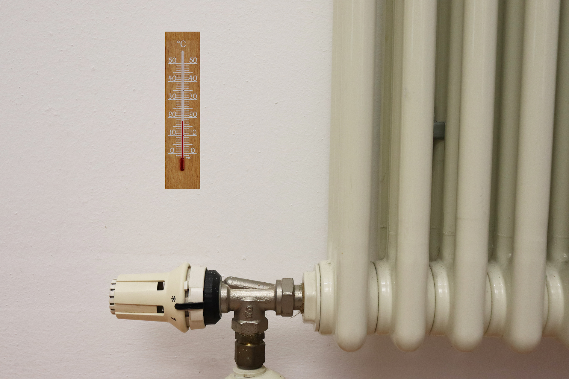 Nahaufnahme Heizkörper mit Thermometer an der Wand
