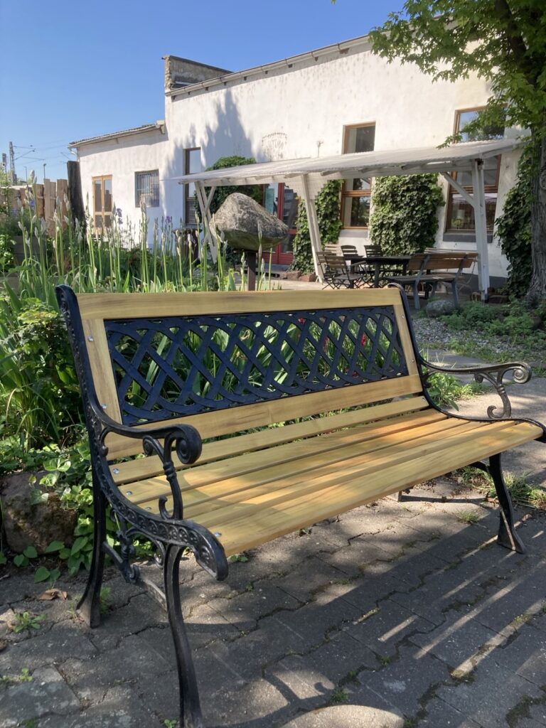 klassische Gartenbank mit schwarzem Gestell und Holzleisten