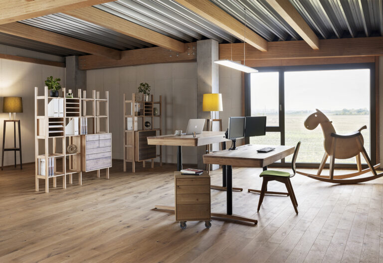 luftiges Büro mit Holzboden und Holzmöbeln