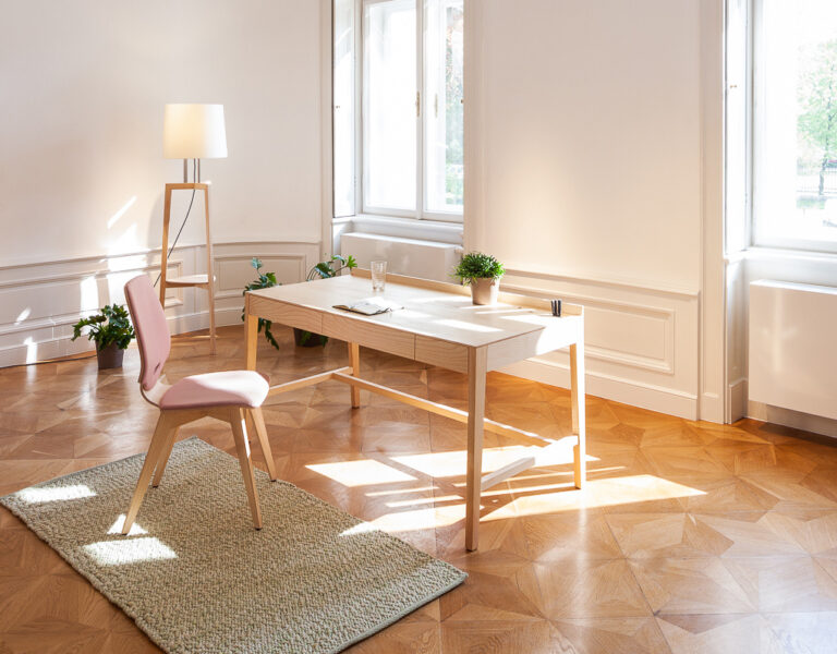 heller Schreibtisch mit rosa Stuhl in einer Altbauwohnung