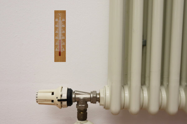 Nahaufnahme Heizkörper mit Thermometer an der Wand